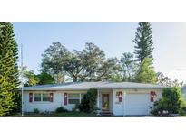 House exterior featuring a white single story home with red accents and a spacious yard at 1321 S Evergreen Ave, Clearwater, FL 33756