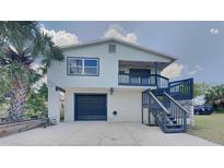 Two-story house with gray accents, a balcony, and a garage at 6728 Sea Ranch Dr, Hudson, FL 34667