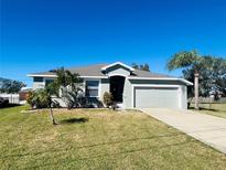 Single-story home with a gray exterior, attached garage, and well-manicured lawn at 6336 Florida Cir, Apollo Beach, FL 33572