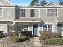 Two-story townhome with gray siding, landscaping, and a walkway at 2346 Lake Woodberry Cir, Brandon, FL 33510