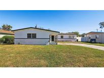 Charming single-story home with a well-maintained front lawn and classic curb appeal on a sunny day at 6007 Ambassador Dr, Tampa, FL 33615
