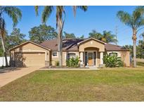 One-story house with a two-car garage and landscaped yard at 13145 Arkendale St, Spring Hill, FL 34609