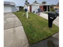 Landscaped front yard with driveway and mailbox at 3741 Baden Dr, Holiday, FL 34691