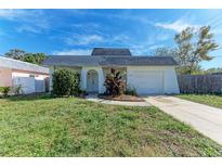 White house with gray roof, landscaping, and driveway at 12229 Eldon Dr, Largo, FL 33774