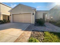 House exterior featuring a two-car garage and landscaped front yard at 6223 Springmont Loop, Palmetto, FL 34221