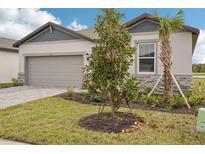 New home with landscaping, paver driveway, and inviting front entrance at 104 Runaway Field Ave, Nokomis, FL 34275