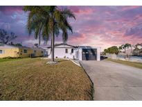 White single-story home with a gray garage door and palm trees at 4059 Orient Dr, Hernando Beach, FL 34607