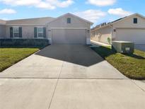 Two-car garage and well-maintained front yard with a long driveway at 17827 Turning Leaf Cir, Land O Lakes, FL 34638