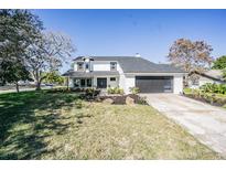 Charming two-story home featuring a well-manicured lawn and a modern garage door at 6370 Conniewood Sq, New Port Richey, FL 34653