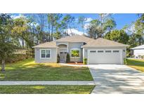 A beautiful one-story house with a two-car garage and landscaped yard at 5277 Epping Ln, Zephyrhills, FL 33541