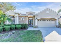 Tan two-story house with stone accents, double garage, and manicured lawn at 3832 5Th Ne Ave, Bradenton, FL 34208