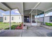Covered screened porch with paver patio and landscaped area at 3145 Hidden Lake Dr, Wesley Chapel, FL 33543