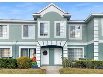 Two-story townhome with a light green exterior, two front doors, and landscaping at 1663 Fluorshire Dr, Brandon, FL 33511