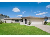 Single-story home with a well-maintained lawn and attached garage at 23104 Newcun Ave, Punta Gorda, FL 33980