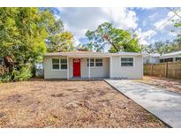 Cute bungalow style home with a red door and landscaped yard at 3723 N Garrison St, Tampa, FL 33619