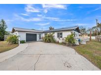White house with gray roof, driveway, and landscaping at 1490 Fundy Rd, Venice, FL 34293