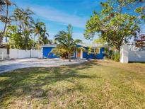 Newly painted blue house with a green lawn and palm trees at 4430 Huntington Ne St, St Petersburg, FL 33703