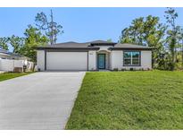 Inviting single-story home featuring a manicured lawn and a modern, two-car garage at 4495 Eldron Ave, North Port, FL 34286