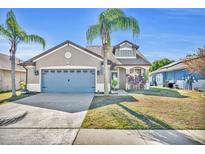 Suburban house with blue garage door and palm trees in the front yard at 304 Tavernier Dr, Oldsmar, FL 34677