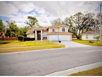 Two-story house with attached two-car garage, landscaping and driveway at 10402 Ashley Oaks Dr, Riverview, FL 33578