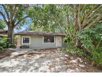 Ranch style home with carport, mature landscaping, and a fenced yard at 4135 Bell Ave, Sarasota, FL 34231