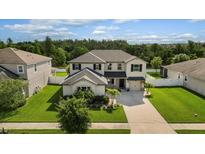 Two-story house with a landscaped yard and driveway at 12211 Streambed Dr, Riverview, FL 33579