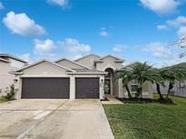 House exterior featuring a two-car garage and well-maintained landscaping at 34434 Windknob Ct, Wesley Chapel, FL 33545