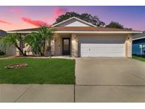 Charming one-story home with a well-manicured lawn and two-car garage at 15427 Winter Breeze Ln, Wimauma, FL 33598
