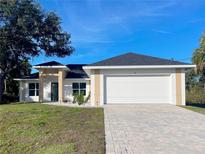 Charming single-story home featuring a well-manicured lawn, brick paved driveway, and attached two-car garage at 37 Warrington Blvd, Port Charlotte, FL 33954