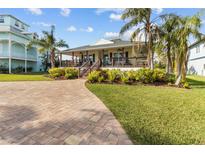Charming single-story home with a covered front porch, brick driveway, and lush landscaping at 505 Sally Lee Dr, Ellenton, FL 34222