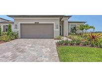 Beautiful single Gathering home with a two-car garage, brick driveway, and manicured landscaping at 14370 Hammock Oak St, Parrish, FL 34219