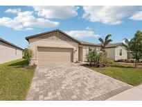 Attractive home with a paver driveway, a two-car garage, and manicured front yard at 466 Sun Chaser Dr, Nokomis, FL 34275