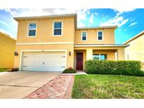 Two-story home with a well-manicured lawn, brick walkway, attached garage, and welcoming front porch at 109 Tierra Verde Way, Bradenton, FL 34212