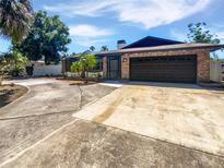 Charming single-story brick home featuring a spacious driveway and attached two-car garage at 2956 Laurel Ct, Dunedin, FL 34698