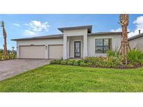 Beautiful single-story home with a manicured lawn, attached garage, and lovely landscaping at 14451 Coastal Woodland Ln, Parrish, FL 34219