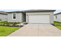 The exterior of the home features a two-car garage and simple landscaping at 225 Lazy Shore Dr, Nokomis, FL 34275