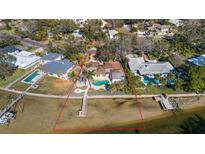 Waterfront home boasts a private pool, mature landscaping, and a dock with direct access to the open bay at 103 Shore Dr, Dunedin, FL 34698