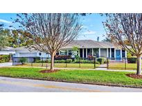 Charming single-story home featuring a manicured lawn, complemented by a stylish black fence and mature trees at 105 17Th Ne Ave, St Petersburg, FL 33704