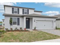 Charming two-story home with neutral paint, complemented by a two-car garage and landscaped yard at 1867 Draughton Dr, Zephyrhills, FL 33541