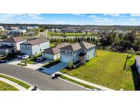 Beautiful aerial view of two-story home with attached garage and sprawling green lawn in suburban neighborhood at 9189 Royal River Cir, Parrish, FL 34219