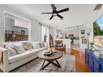 Bright living room featuring a comfortable sofa, ceiling fan, and an open floor plan to the modern kitchen at 2607 W Cleveland St # B, Tampa, FL 33609