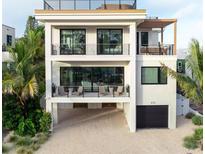 Stunning three-story modern home with balconies and tropical landscaping in a beach community at 415 N Bay Blvd, Anna Maria, FL 34216