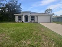 Charming single-story home with a well-manicured lawn and neutral color scheme at 3328 Circleville St, North Port, FL 34286