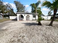 Charming white home with dark roof, decorative archways and abundant shell rock landscaping at 913 27Th E St, Bradenton, FL 34208
