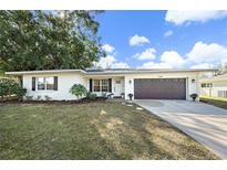 Charming single-story home with a well-manicured lawn, stone walkway, and a two-car garage at 7746 Westmoreland Dr, Sarasota, FL 34243