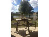 Outdoor patio featuring a table and chairs, perfect for enjoying the serene water view at 7037 Towering Spruce Dr, Riverview, FL 33578