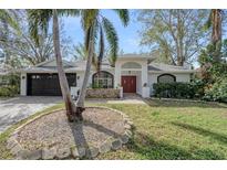 Charming single-story home featuring a well-manicured lawn and a beautiful, mature palm tree in the front yard at 4721 Country Manor Dr, Sarasota, FL 34233