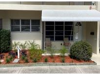 Charming condo entrance featuring a white awning and neatly landscaped garden at 4143 57Th N St # 502, Kenneth City, FL 33709