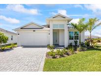 Charming single-Gathering home showcasing a well-manicured lawn and a welcoming, light blue front door at 16397 Preservation Blvd, Punta Gorda, FL 33982