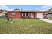 Charming single-story red brick home featuring a well-manicured lawn and inviting curb appeal at 1768 Suffolk Dr, Clearwater, FL 33756